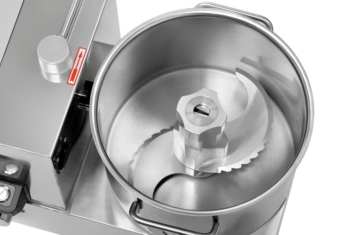 Couteau double lame en inox au fond de la cuve du PC-6, vu de dessus.